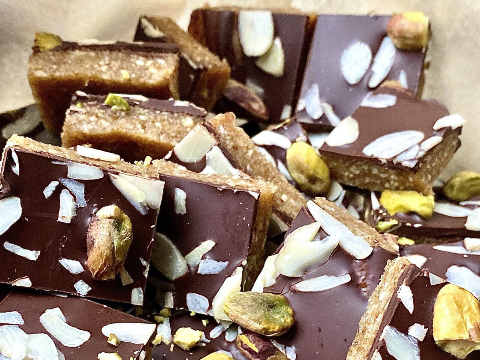A tray of broken up energy bars - chocolate on oats with nuts and coconut.