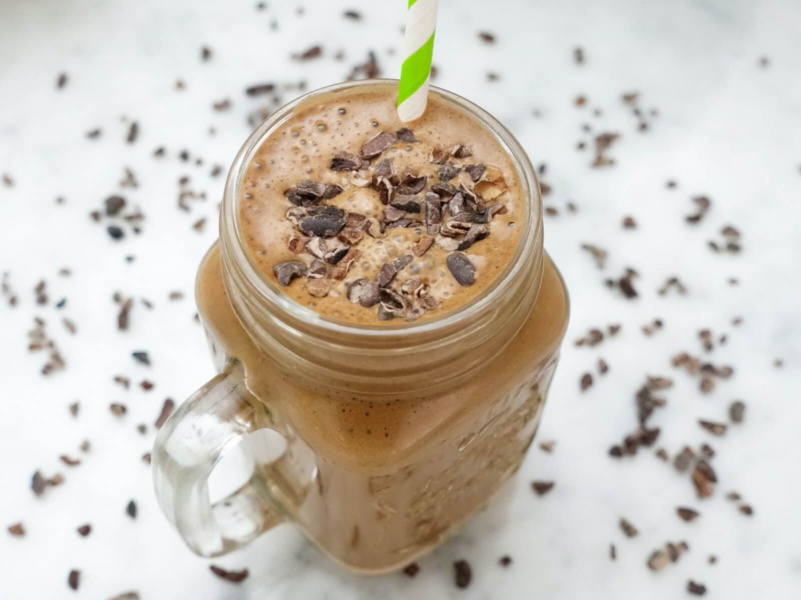 A chocolate protein shake in a glass jar with shaved chocolate on top. An inflammation reducing recipe.