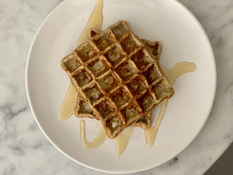 A birds eye view of two waffles with honey drizzled over the top, which is a recipe from an inflammation reduction lifestyle plan.