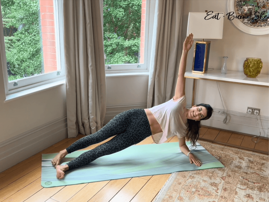 Yalda Alaoui, performing one of her movement exercises in her room on a green mat by the windows.